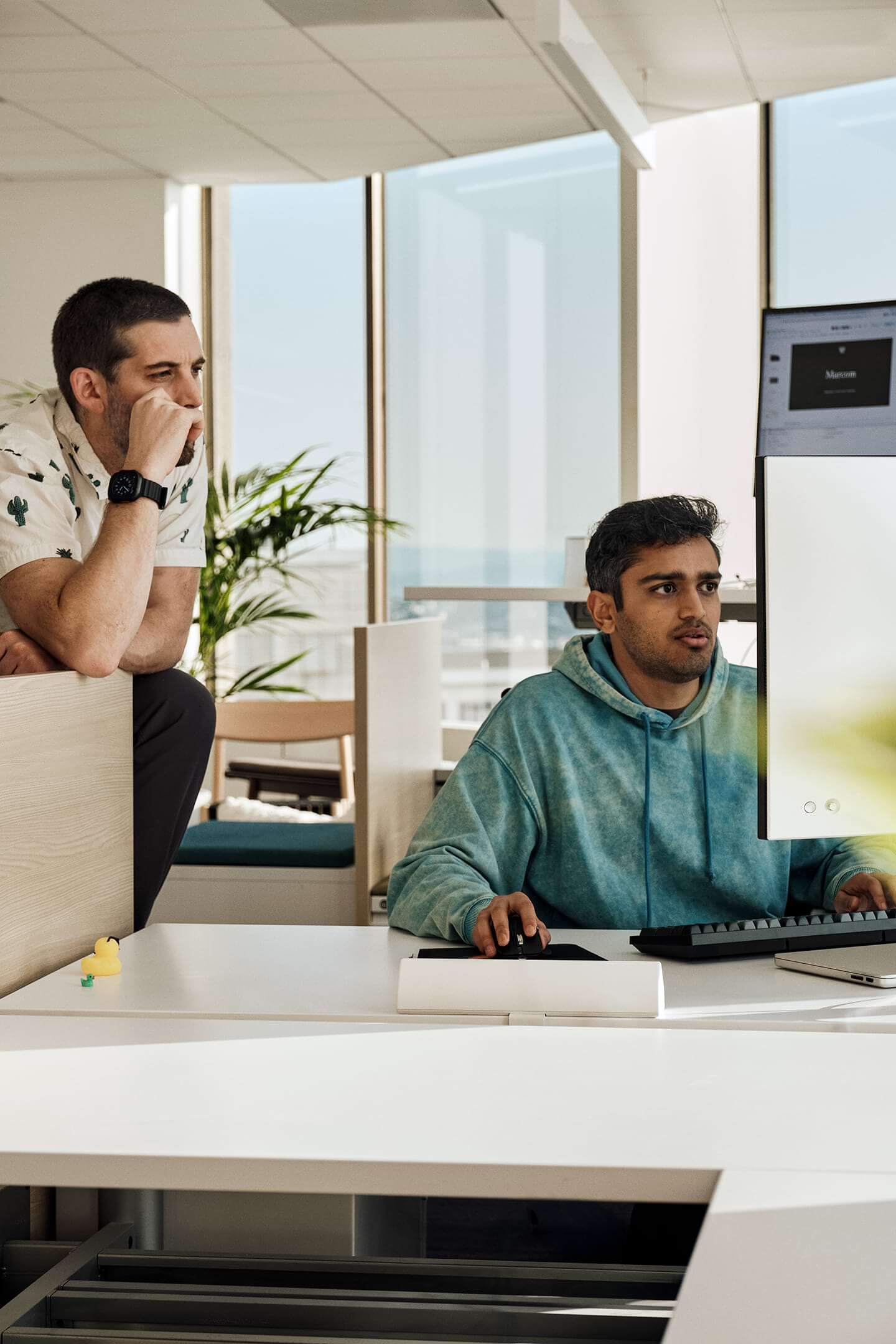 Two engineers reviewing work together at a desk